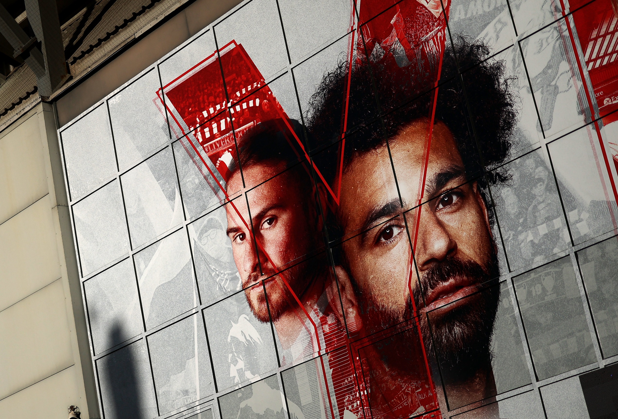 Mo Salah and Alexis Mac Allister's faces on Anfield Stadium.