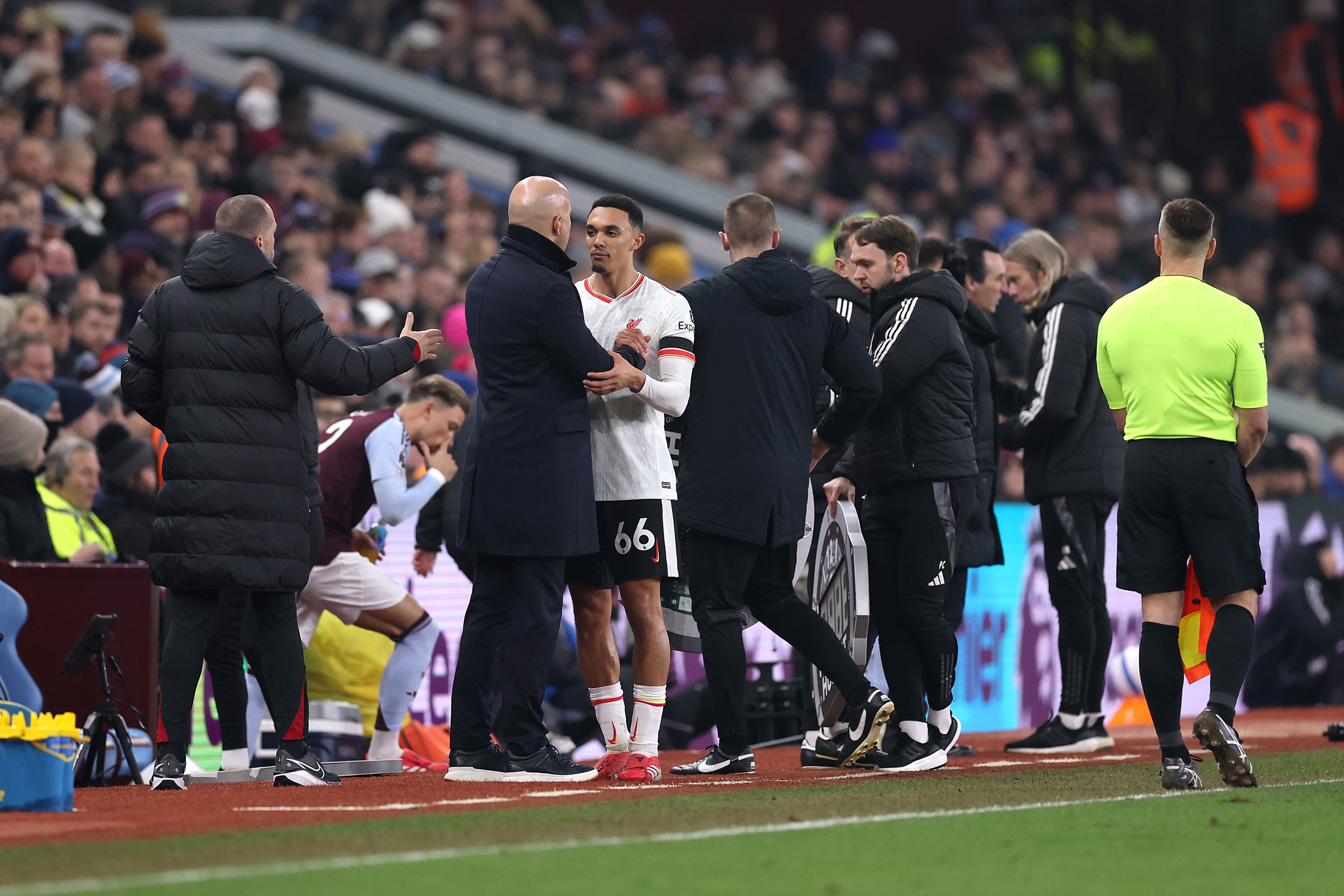 Trent Alexander-Arnold embraces Liverpool head coach Arne Slot on the touchline.