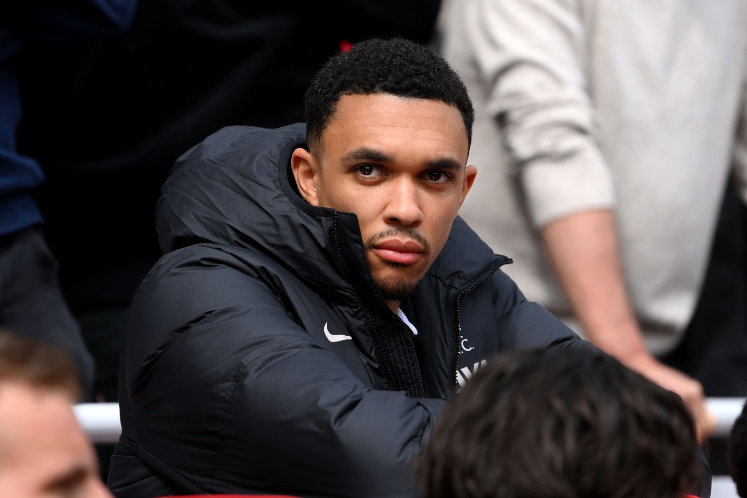 Trent Alexander-Arnold sits behind the bench at Anfield