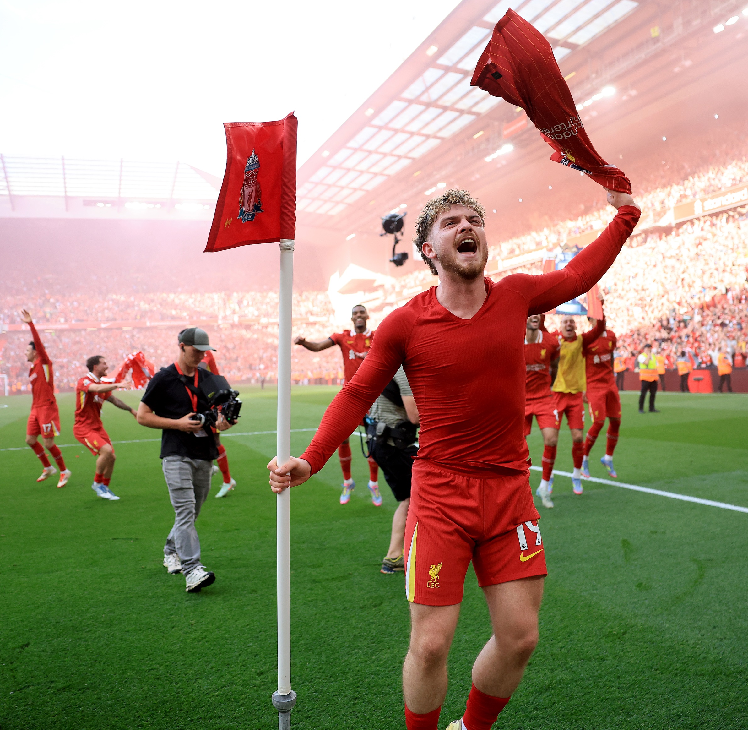 Harvey Elliott waves his shirt next to Liverpool corner flag.