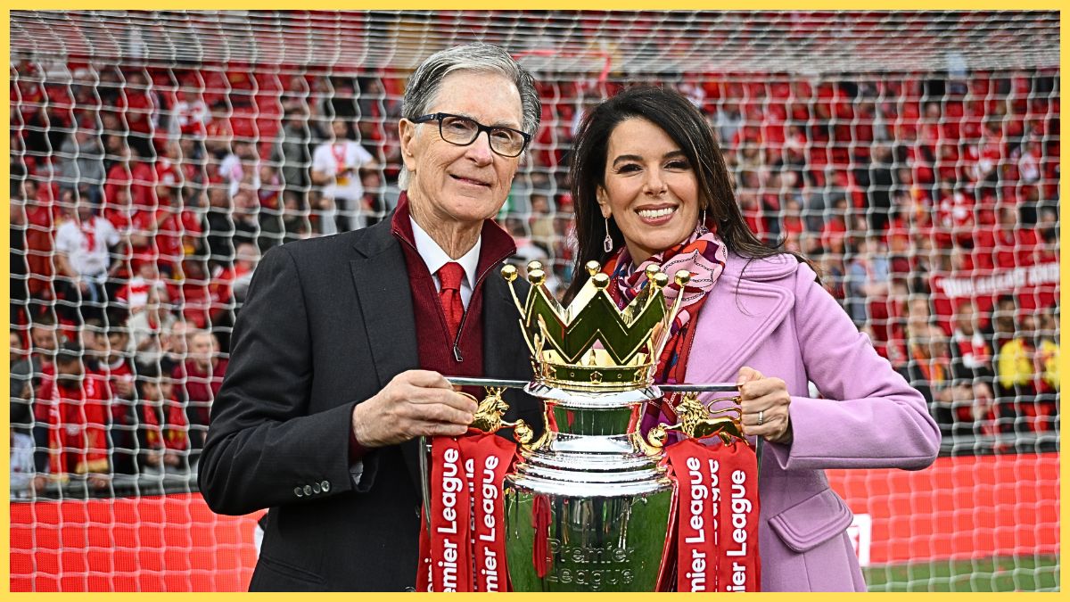 John W Henry and his wife Linda Pizzuti Henry hold the Premier League trophy.