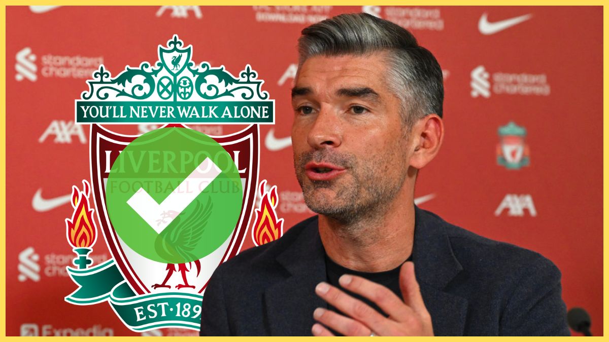 Richard Hughes gestures with his hand mid-speech next to Liverpool club crest.