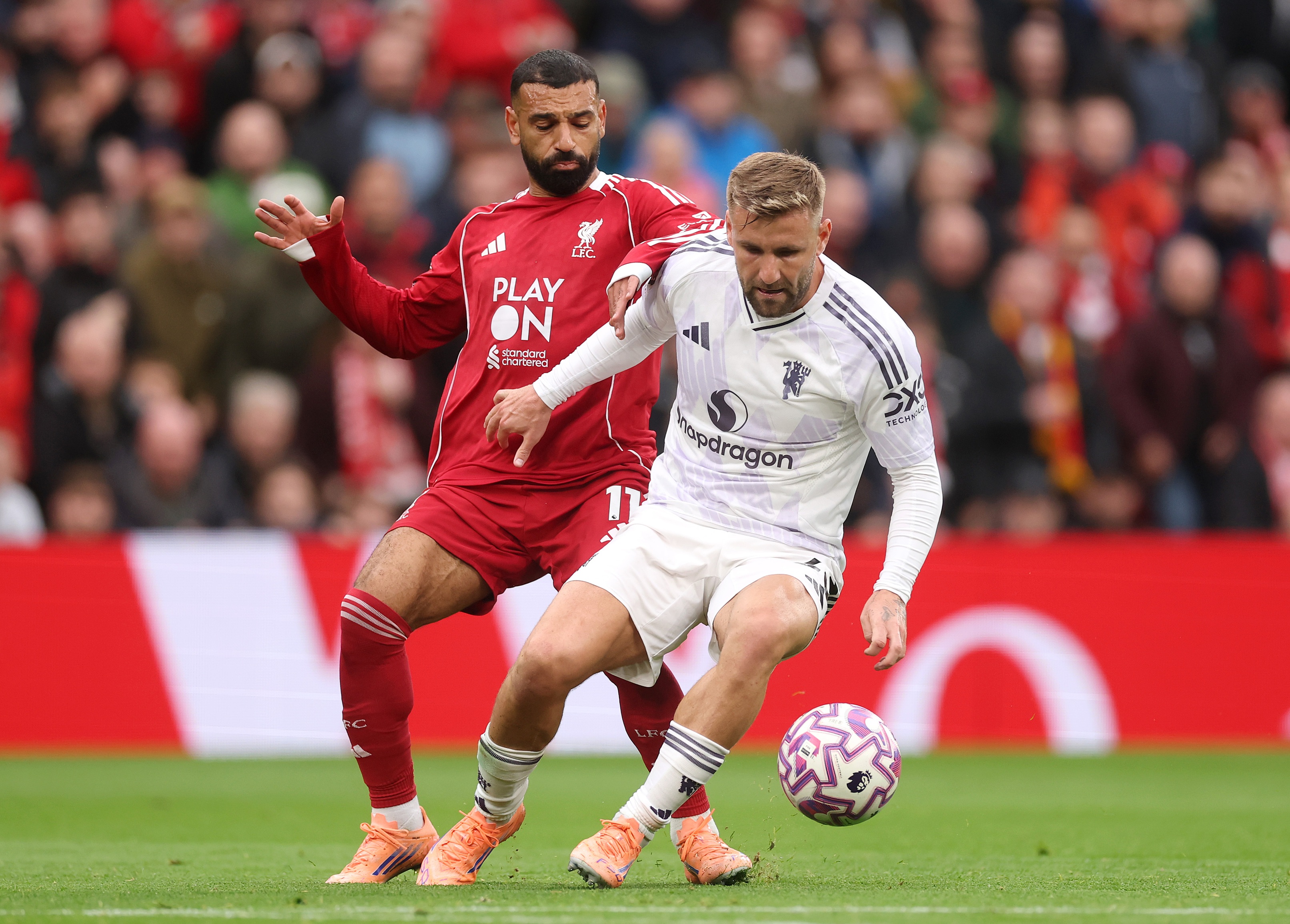 Liverpool winger Mo Salah grapples with Luke Shaw.