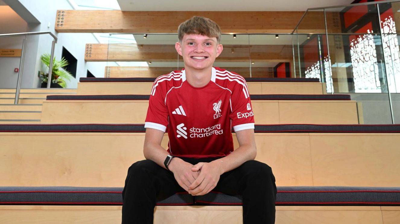 Will Wright smiles and sits on the stairs at the AXA training centre.