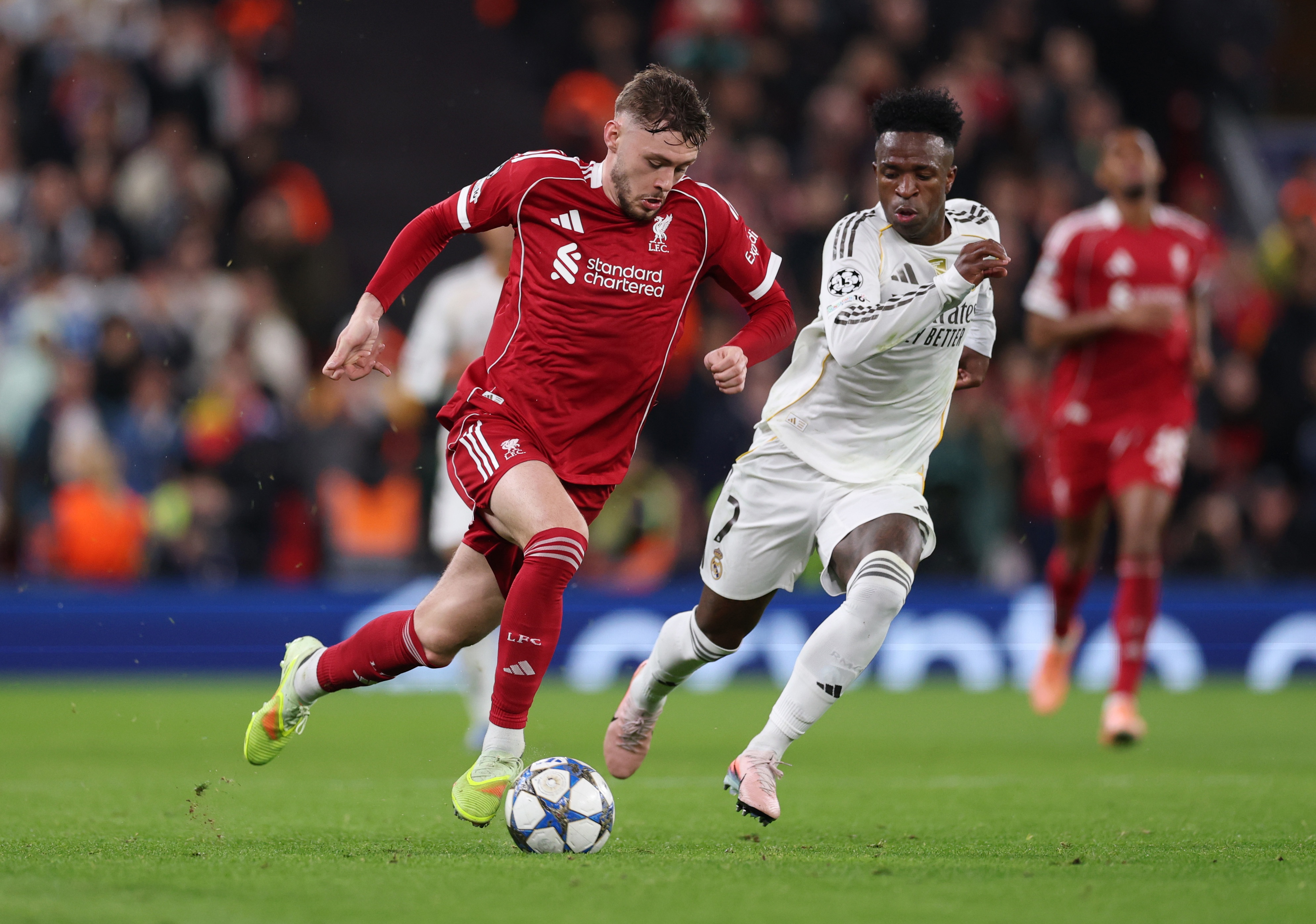 Conor Bradley dribbles with the ball while under pressure from Vinicius Jr.