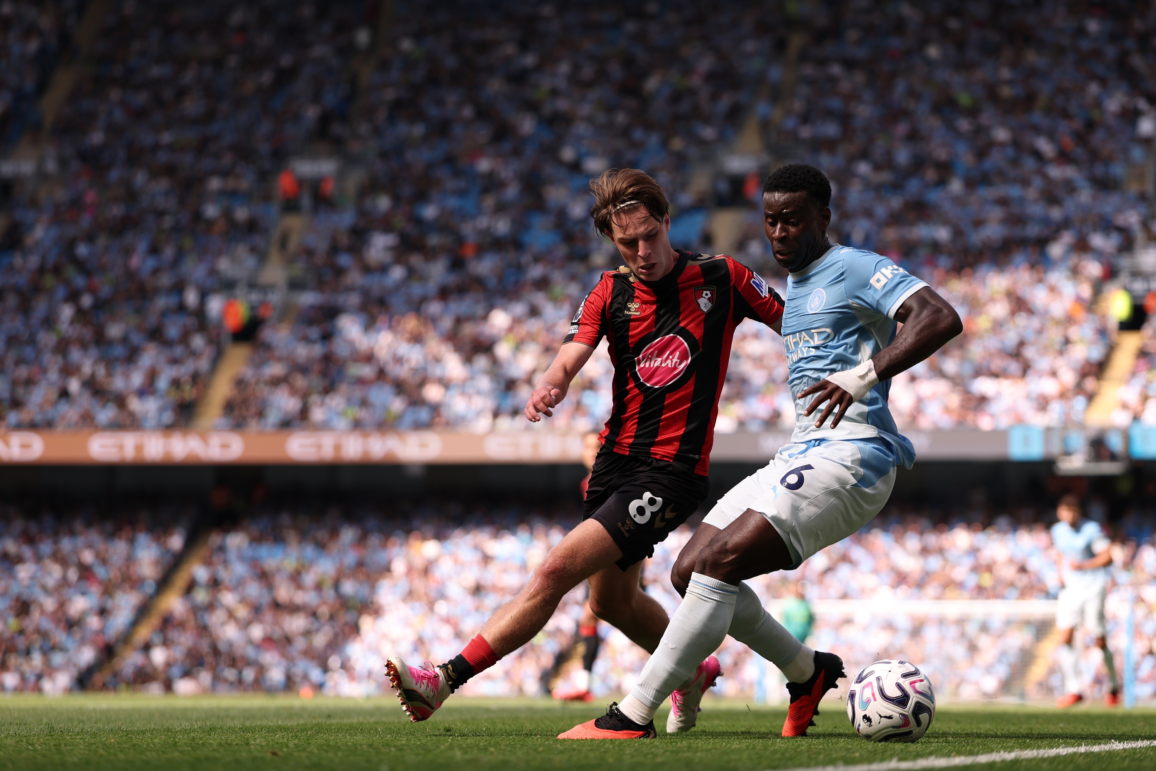 Bournemouth midfielder Alex Scott competes with Manchester City star Marc Guehi for the ball.