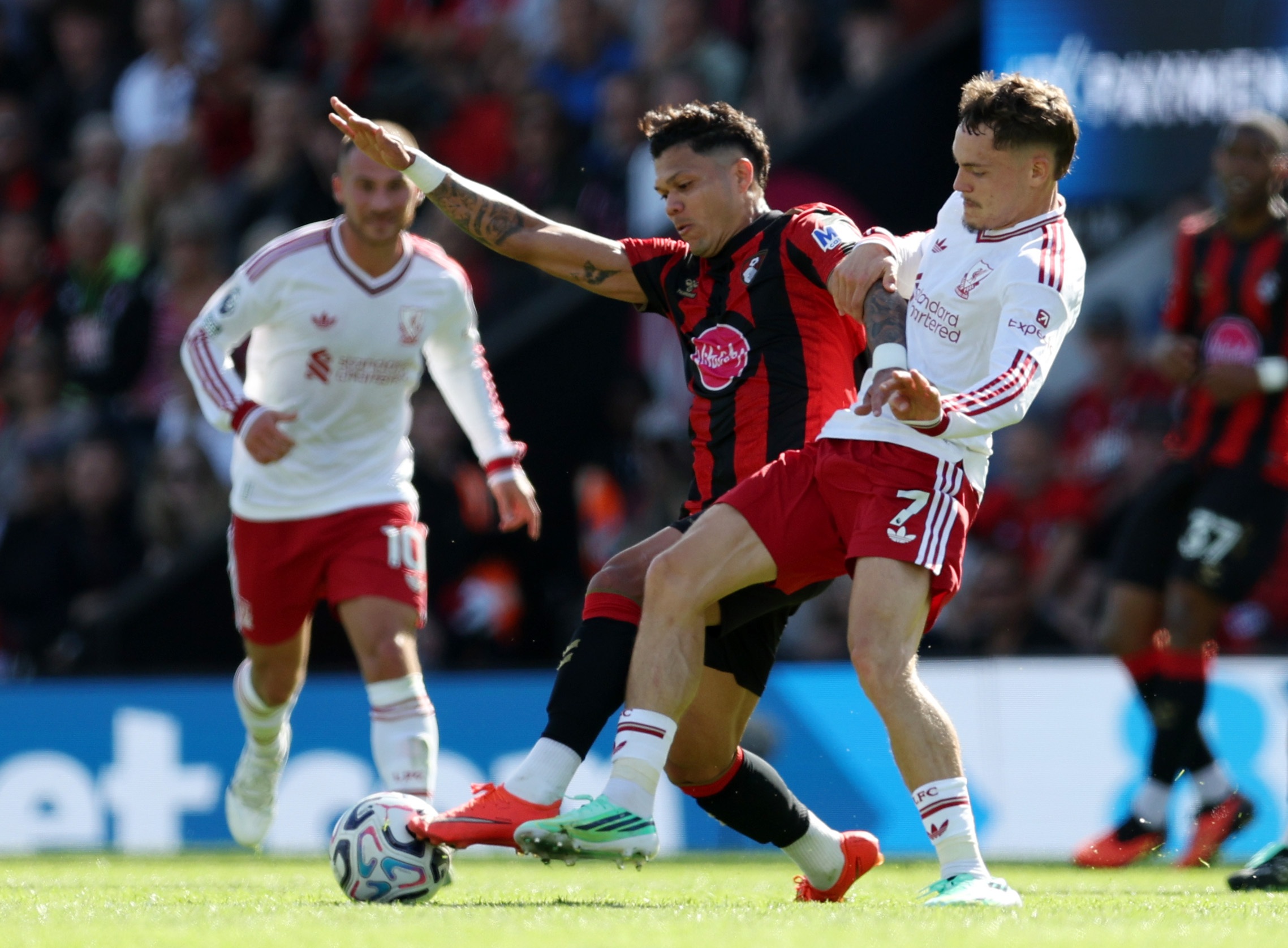Liverpool midfielder Florian Wirtz battles Evanilson for the ball during Premier League game.
