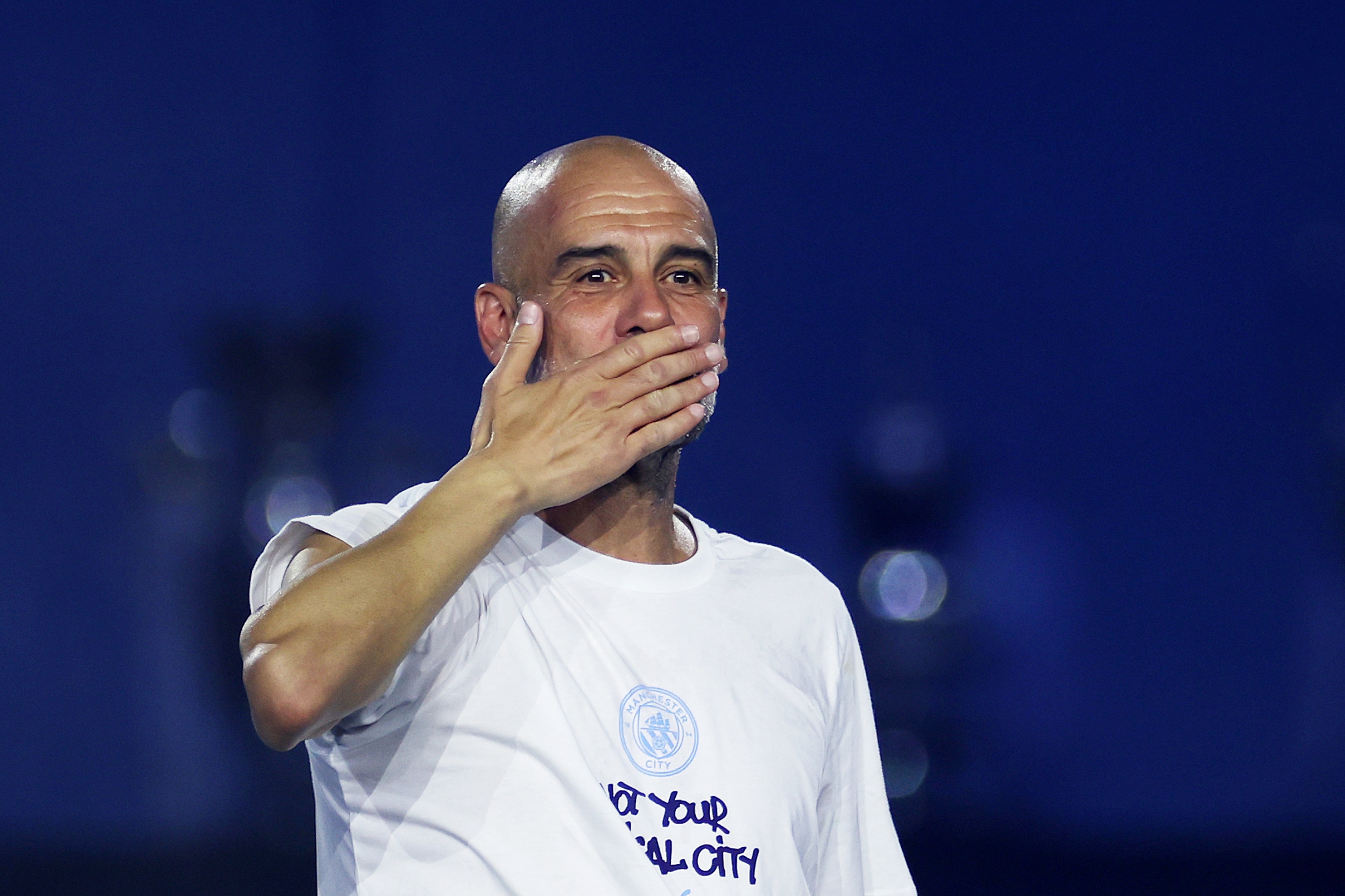 Former Manchester City manager Pep Guardiola covers his mouth with his hand to blow a kiss.