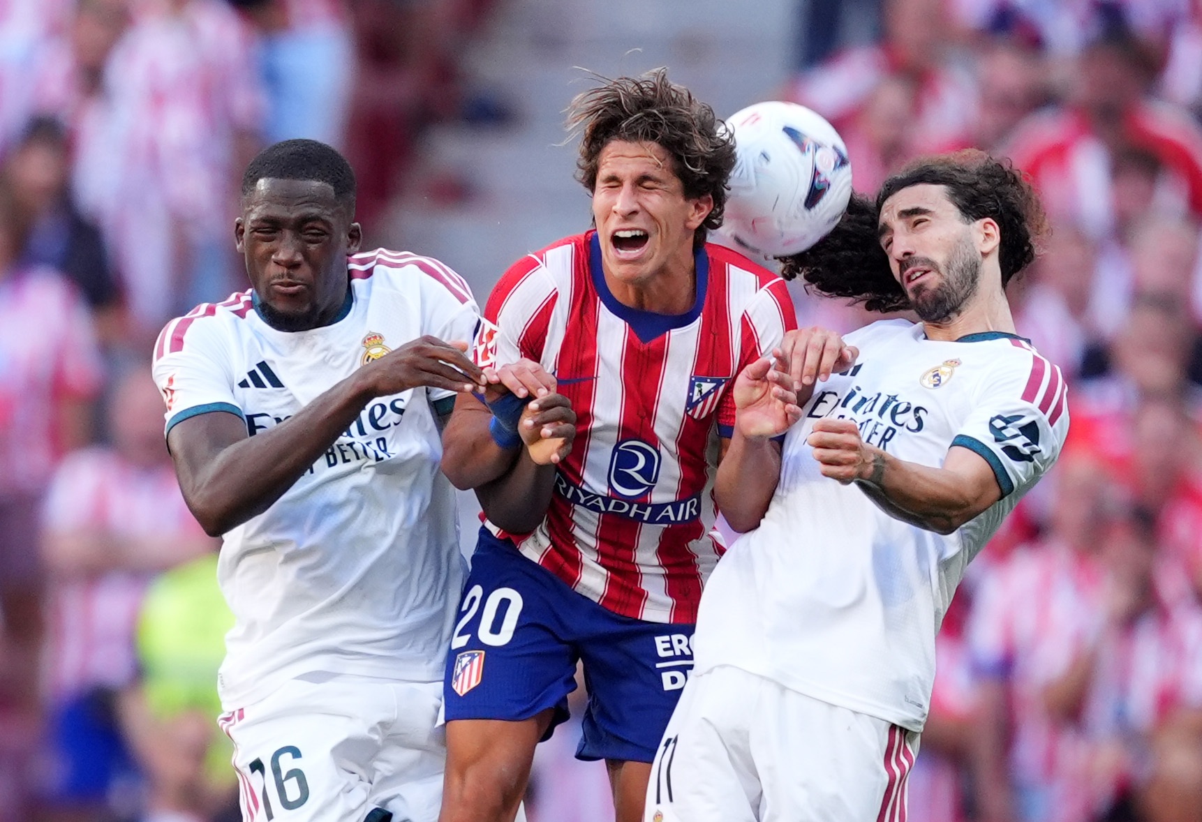 Ibrahima Konate competes with an Atletico Madrid player for a ball in the air.