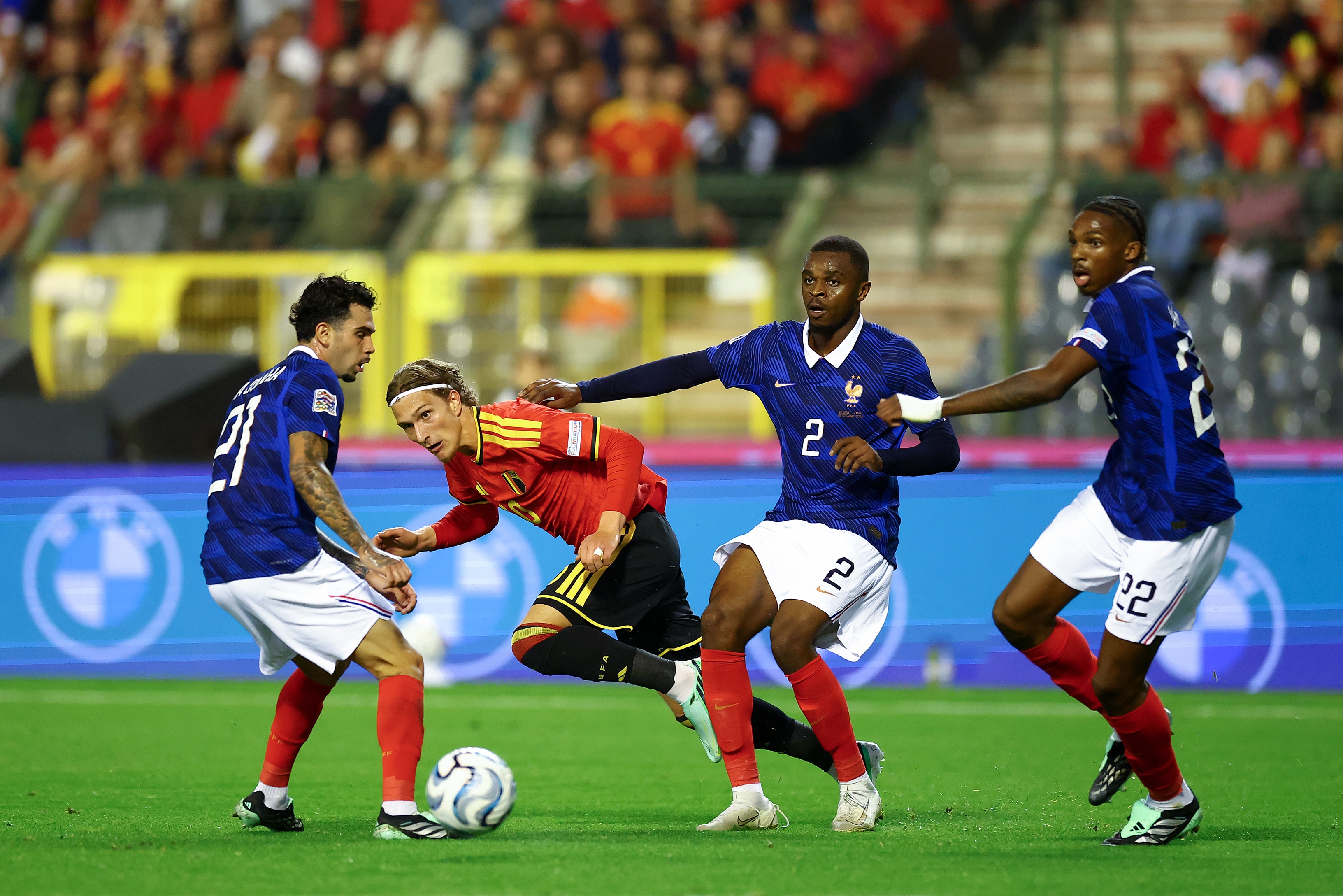 Liverpool centre-back Jeremy Jacquet competes for the ball alongside two France teammates.