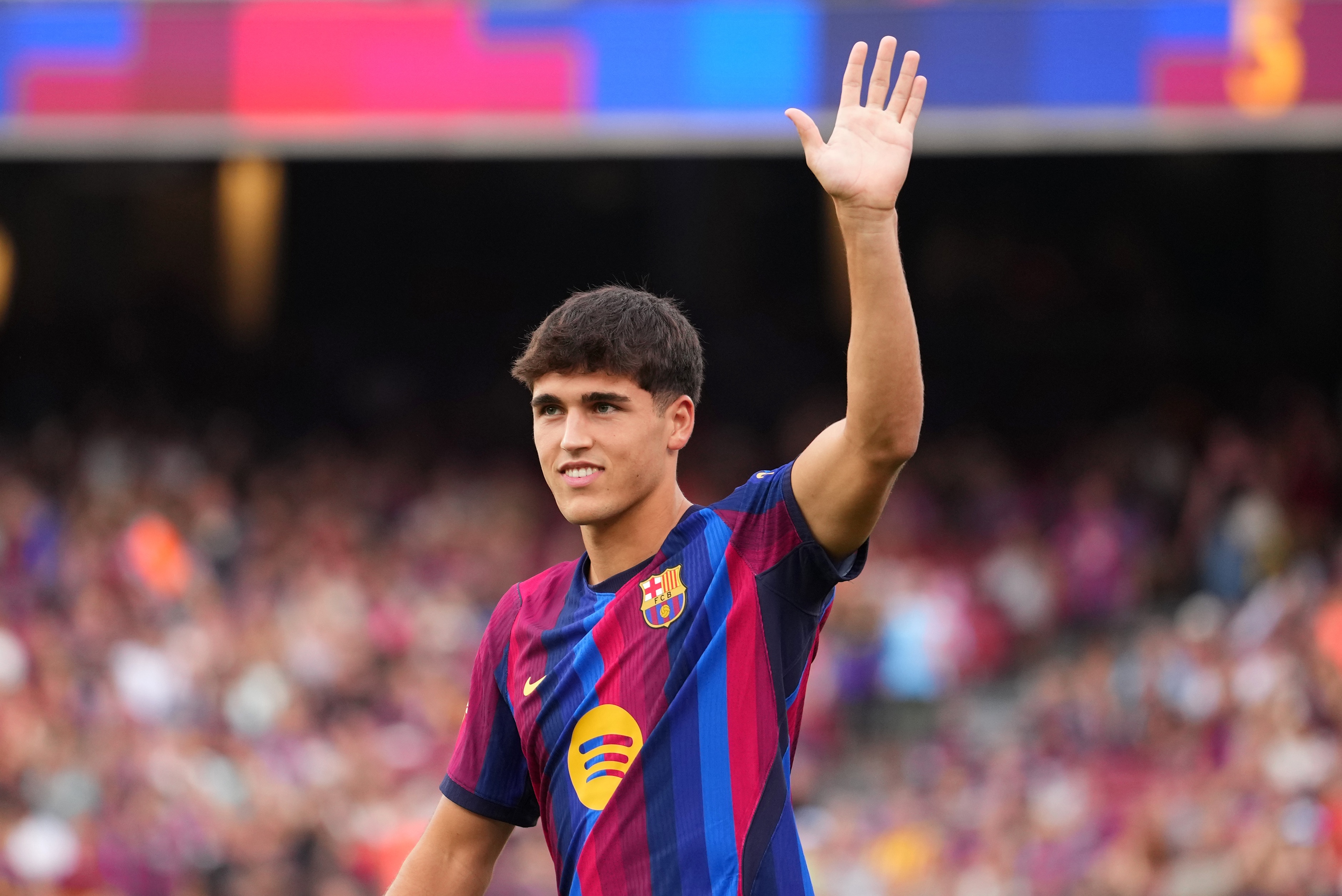 Barcelona centre-back Pau Cubarsi waves to the fans.