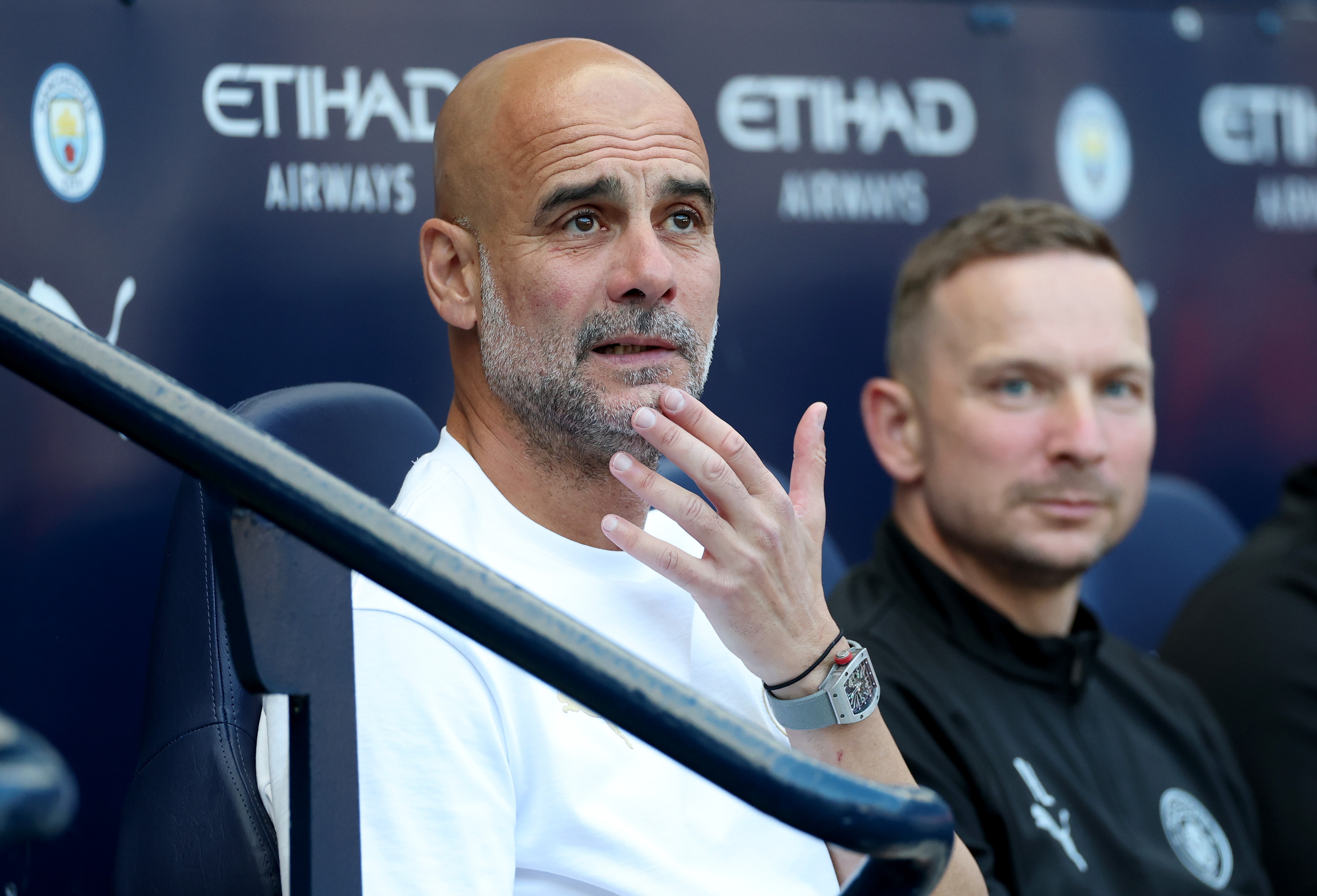 Former Manchester City manager rubs his chin and looks worried.