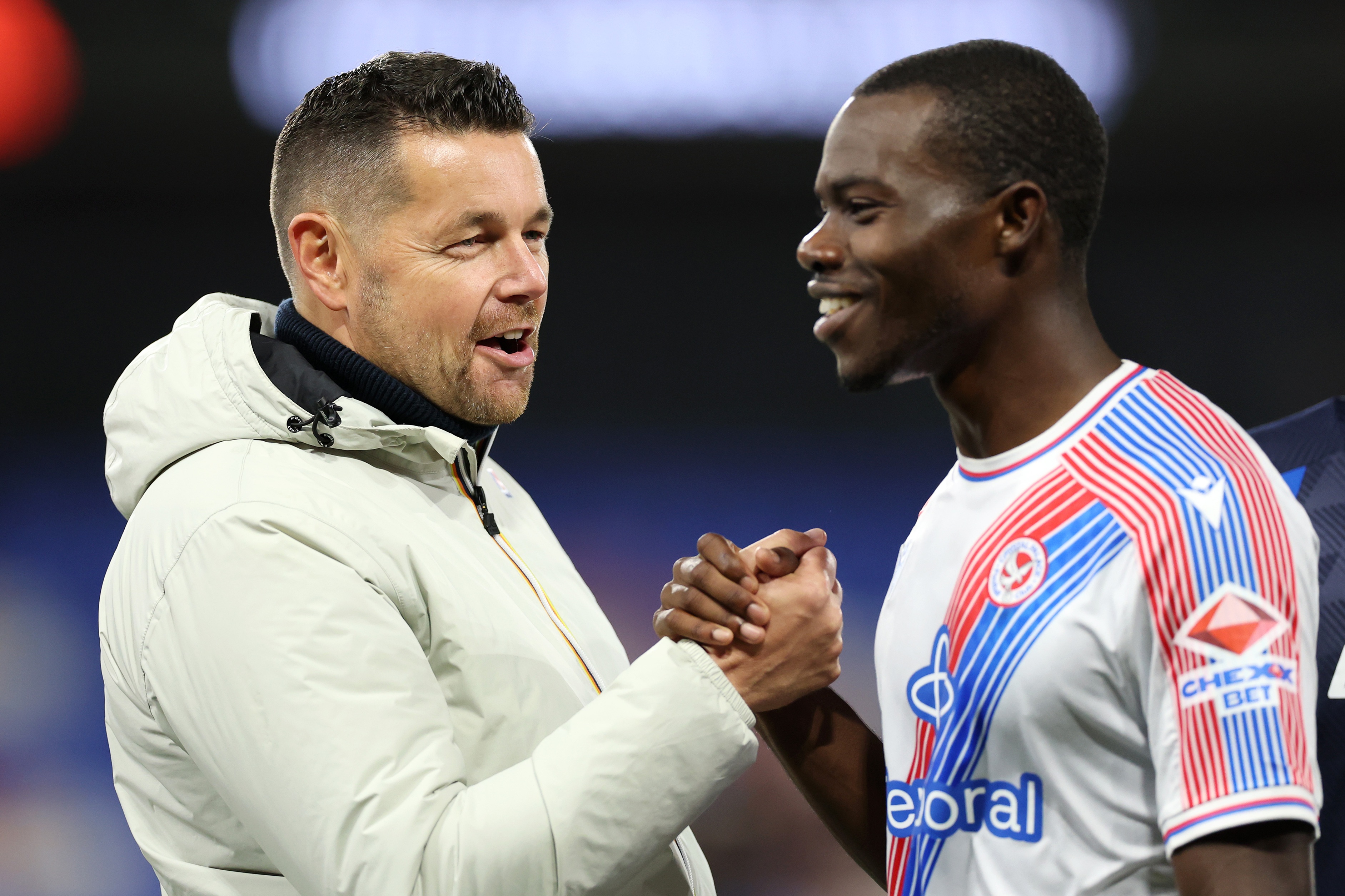 Tyrick Mitchell shakes hands with Crystal Palace head coach Pierre Sage.