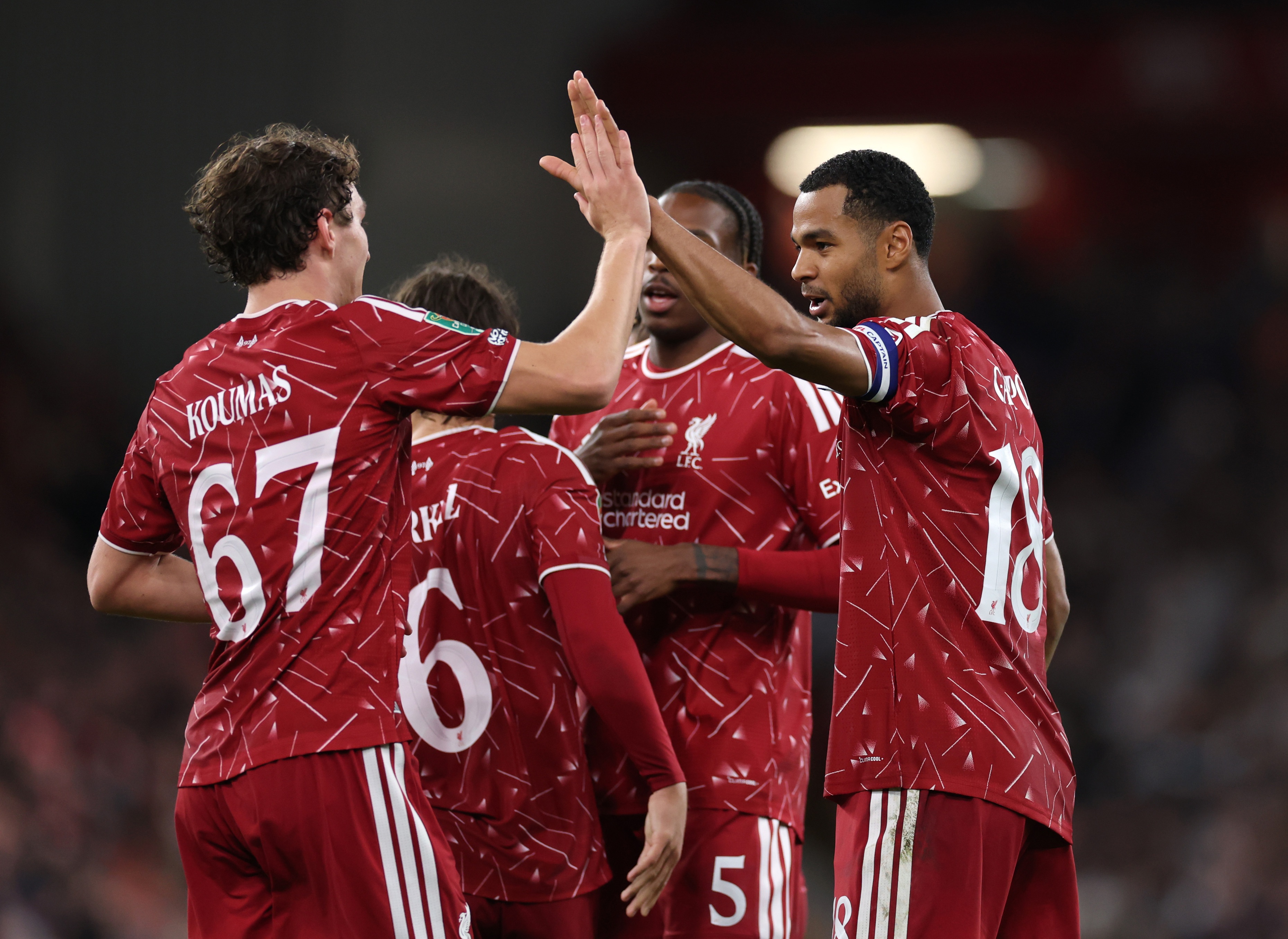 Cody Gakpo high fives Liverpool teammate Lewis Koumas.