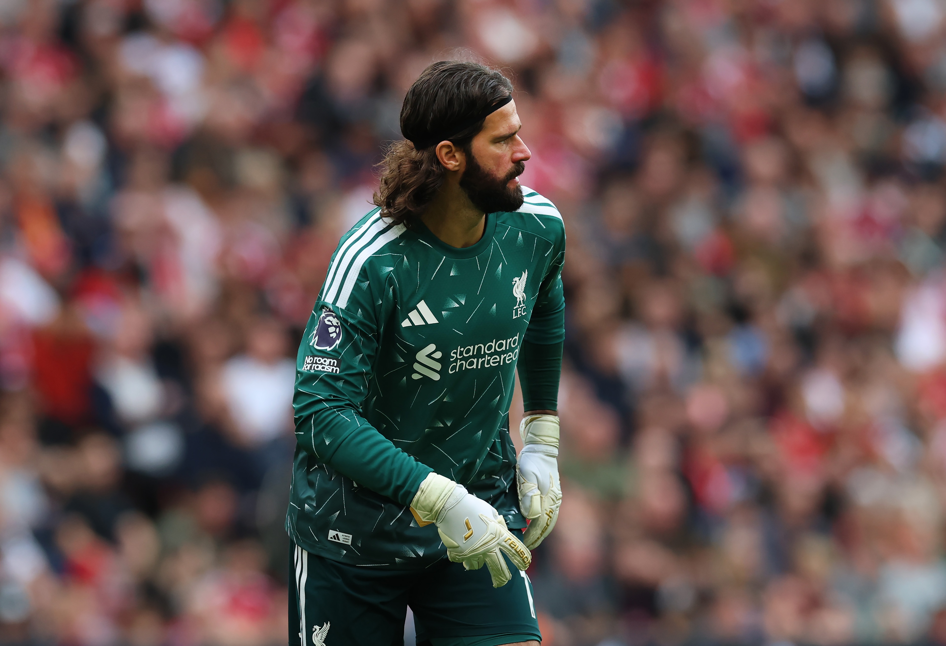 Liverpool goalkeeper Alisson Becker walks on the pitch.