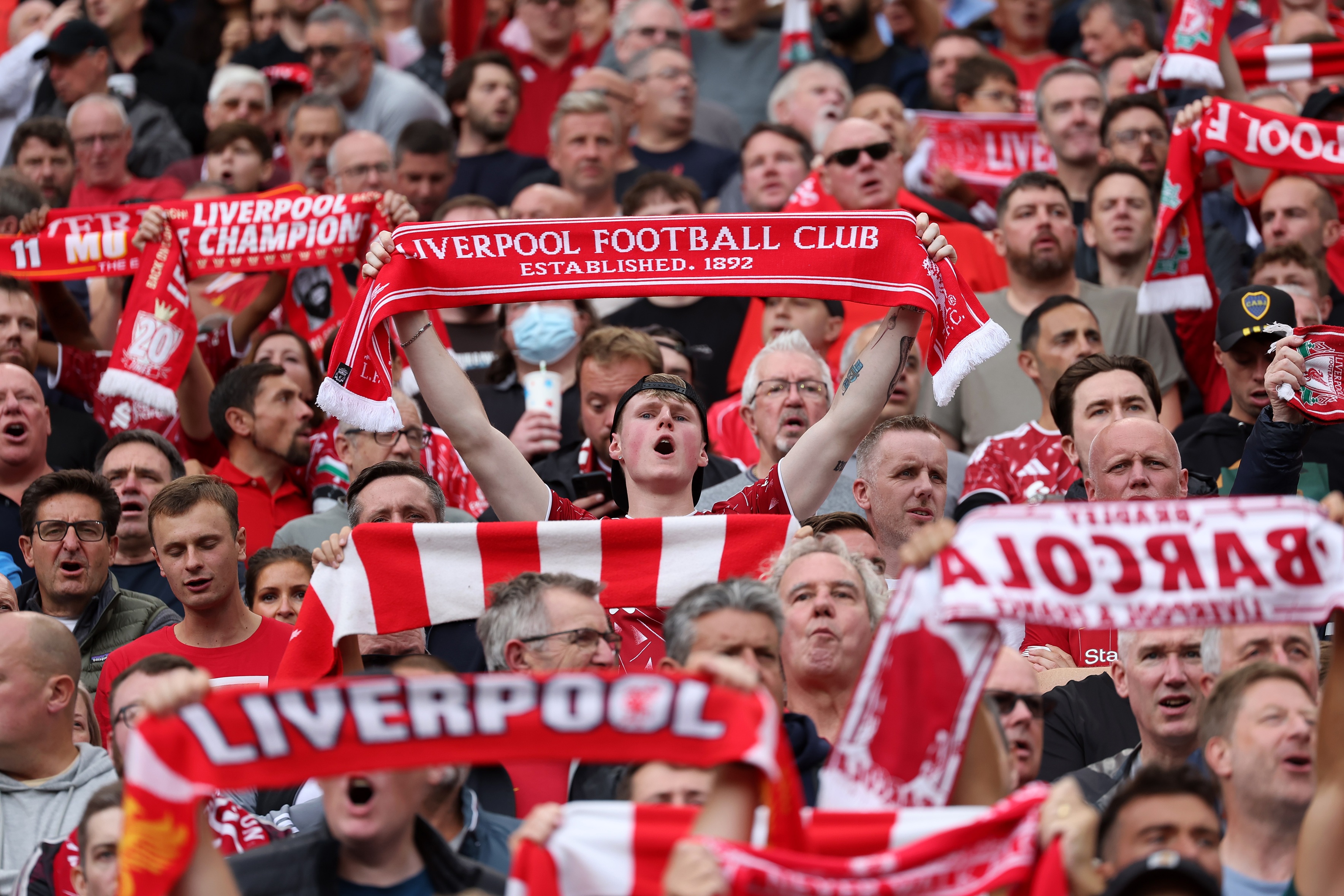 Liverpool fans hold up red scarves at Anfield.