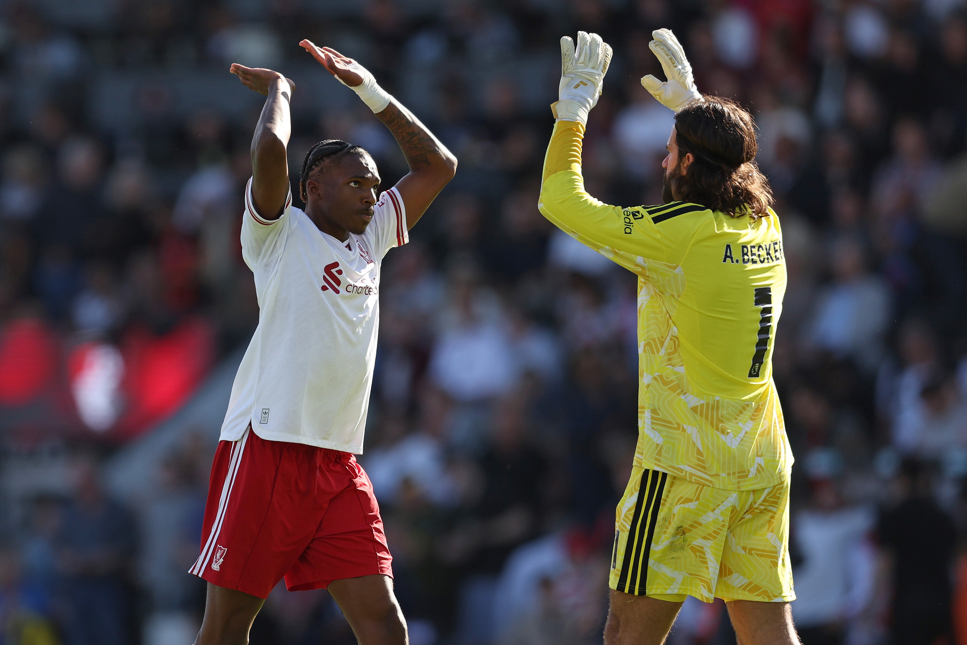 Jeremy Jacquet high fives Liverpool goalkeeper Alisson Becker.