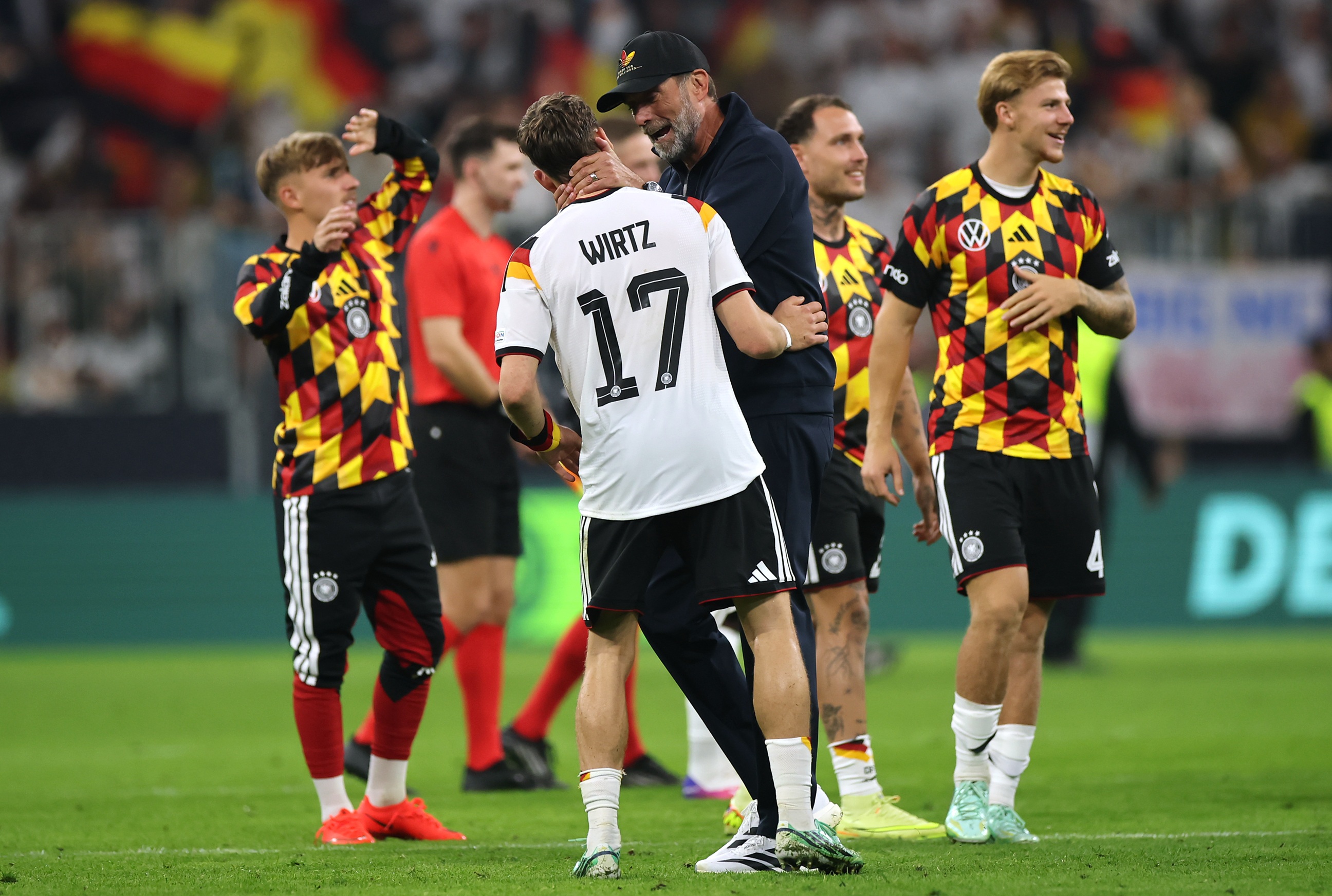 Jurgen Klopp wraps his hands around Liverpool midfielder Florian Wirtz's neck.