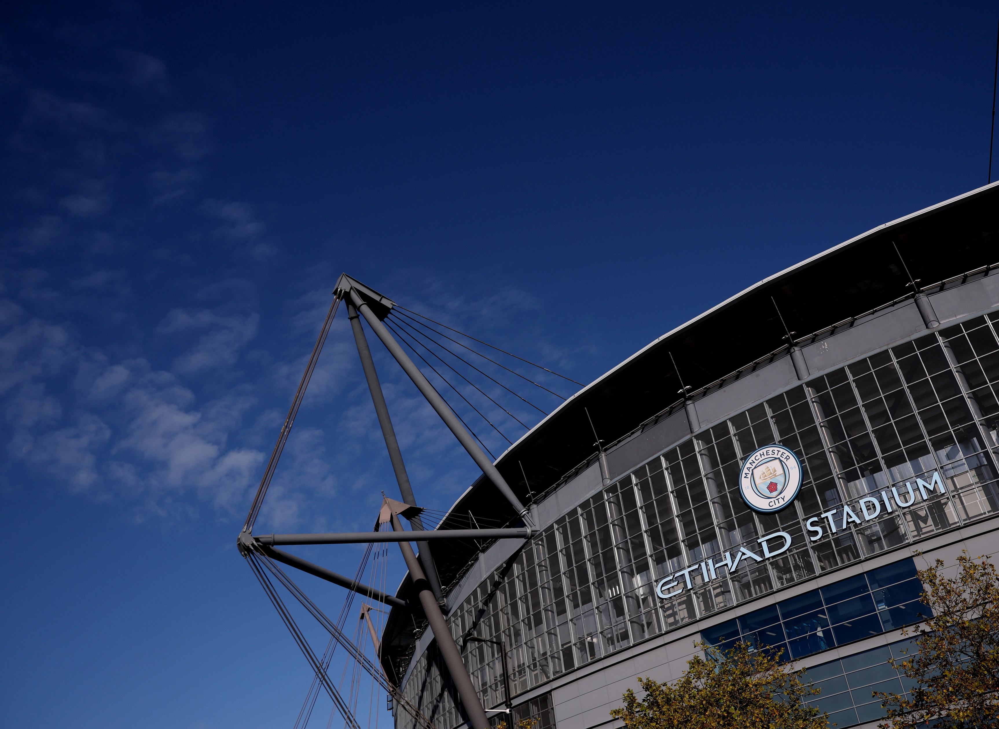 Manchester City's Etihad Stadium next to a blue sky.
