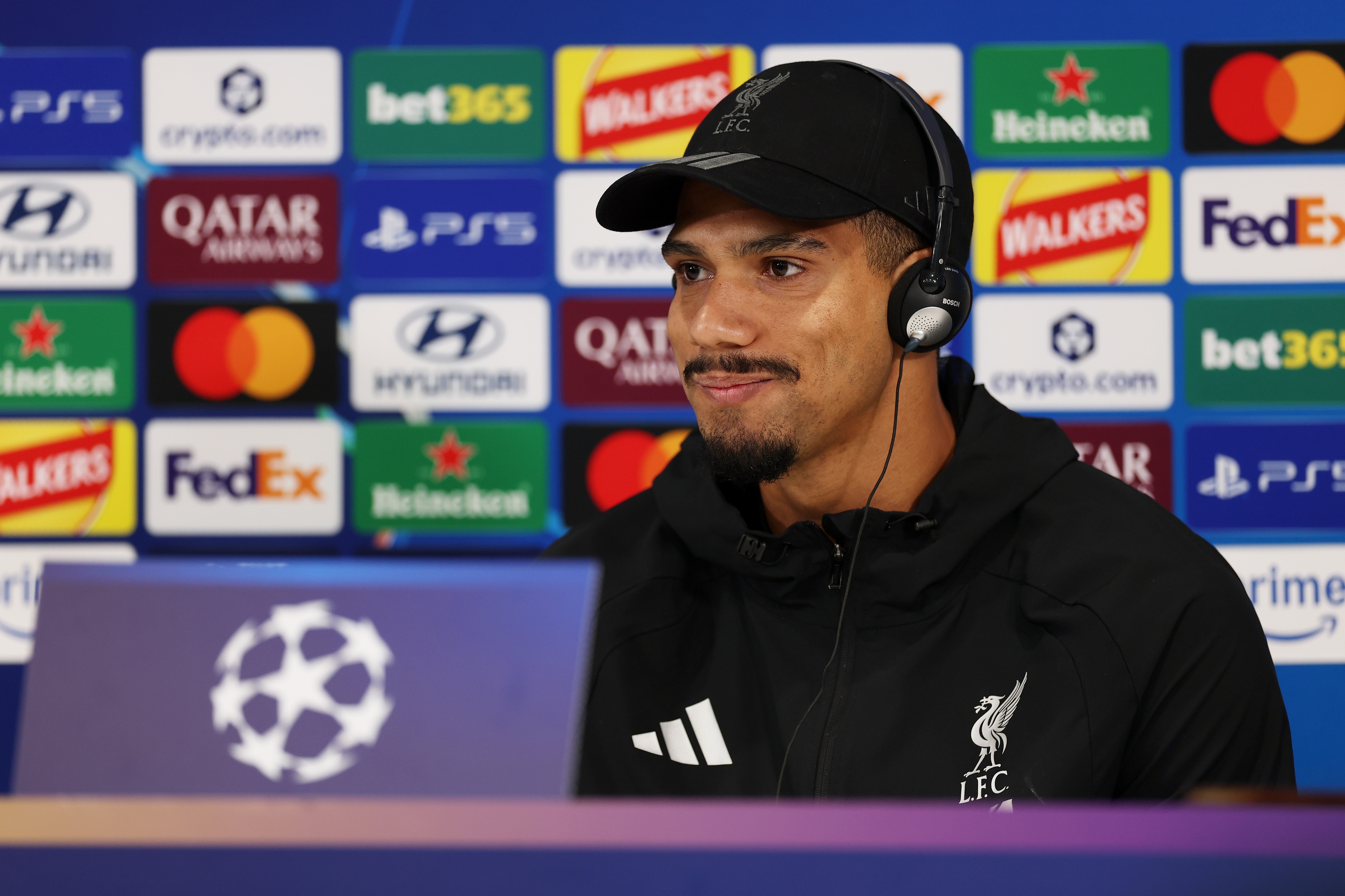 Ronald Araujo smiles while wearing headphones during Liverpool press conference.