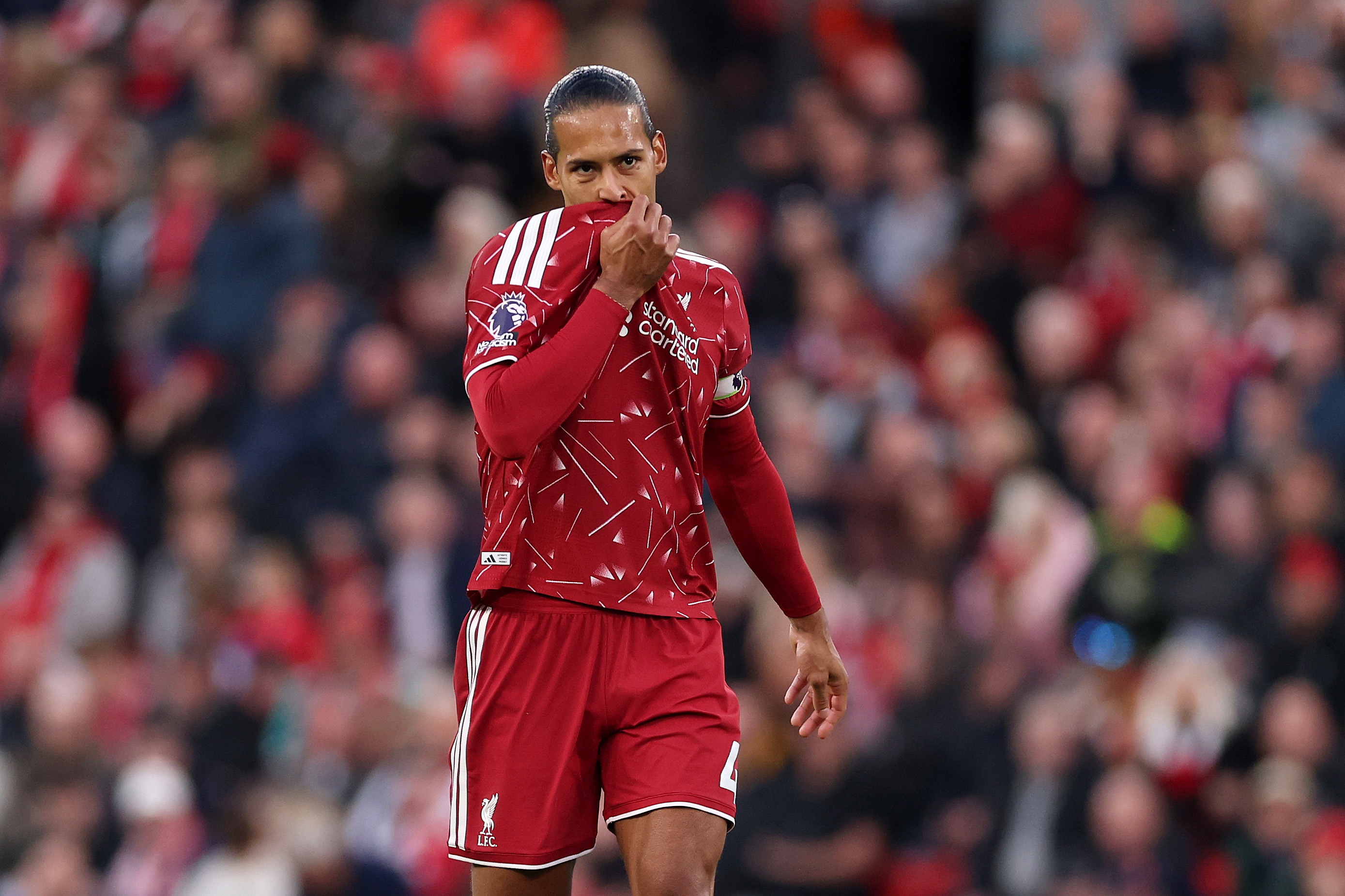 Virgil van Dijk wipes his face with his Liverpool shirt.