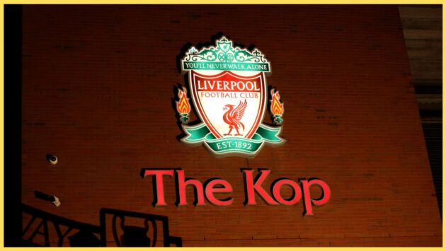 A photo of a neon sign indicating the location of the Kop at Anfield