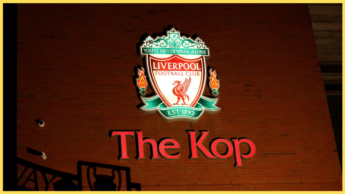 A photo of a neon sign indicating the location of the Kop at Anfield