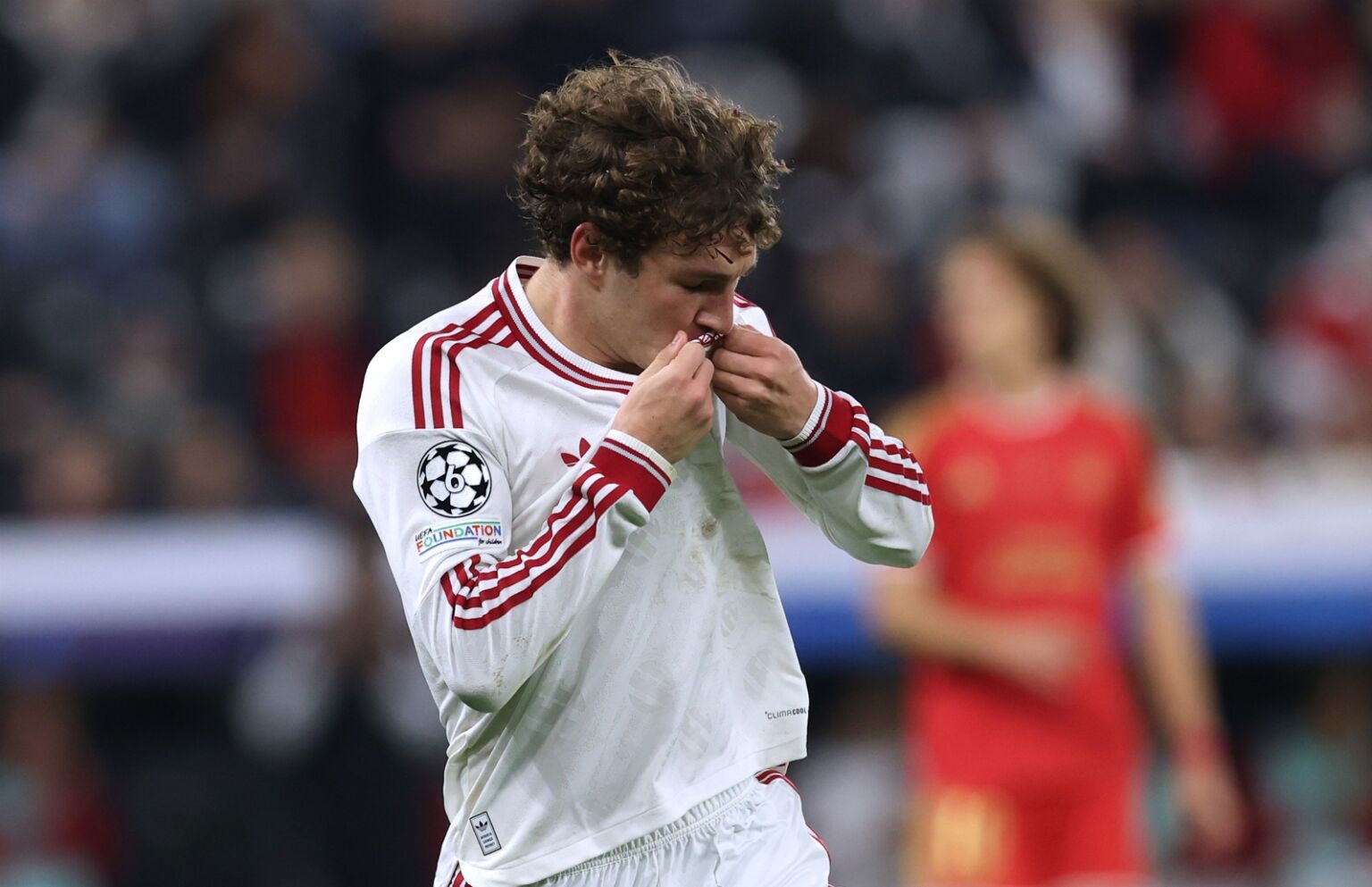 Lewis Koumas kisses the Liverpool crest after scoring against LASK