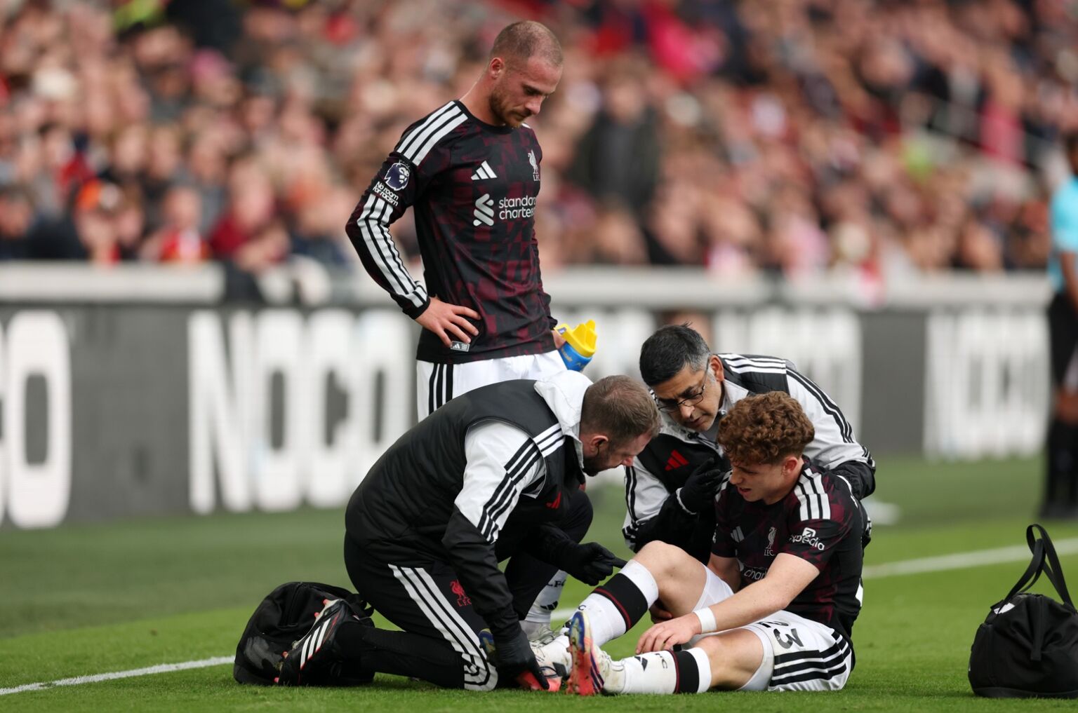 Victor Munoz receives treatment on the pitch during Liverpool's win over Brentford